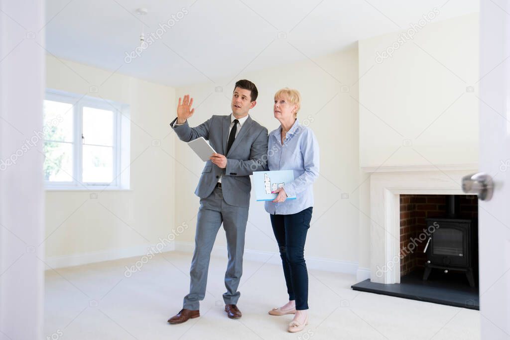 Maklerin führt Interessenten durch eine Wohnung